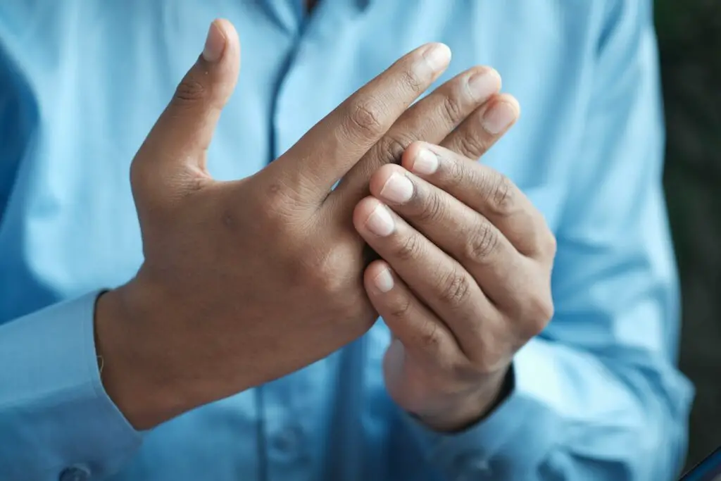 person in blue shirt showing left hand, bone health